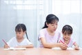 Asian Chinese mother teaching daughters doing homework Royalty Free Stock Photo