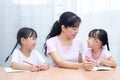 Asian Chinese mother teaching daughters doing homework Royalty Free Stock Photo