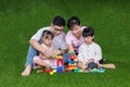 Asian Chinese parents and daughters playing blocks on the grass