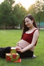Asian Chinese pregnant woman present gift wrap on hands expect baby Merry Christmas holiday concept family parents mom