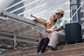 Asian chinese senior tourist couple with black luggage sitting together on stairway urban with map on hand after having city Royalty Free Stock Photo