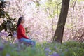 Beautiful young girl Listen to music on a mobile phone while sitting under giant oak