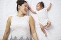 Asian chinese woman mother lying next to newborn child and playing Royalty Free Stock Photo