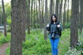 Portrait of a Asian Chinese nature woman photographer look at her camera screen in a spring park forest , with good hand gesture Royalty Free Stock Photo