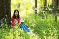 Beautiful young girl reading book while sitting under giant oak