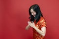 Asian chinese woman with red cheongsam or qipao doing polite respectful gesture for wishing the good luck and prosperity in