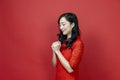 Asian chinese woman with red cheongsam or qipao doing polite respectful gesture for wishing the good luck and prosperity in