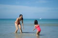 Asian chinese woman spending time playing with daughter at the beach Royalty Free Stock Photo