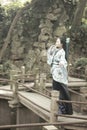 Asian Chinese woman in traditional Blue and white Hanfu dress, play in a famous garden on crooked Bridge Royalty Free Stock Photo