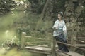 Asian Chinese woman in traditional Blue and white Hanfu dress, play in a famous garden on crooked Bridge Royalty Free Stock Photo