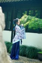 Asian Chinese woman in traditional Blue and white Hanfu dress, play in a famous garden near windows Royalty Free Stock Photo