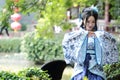 Asian Chinese woman in traditional Blue and white Hanfu dress, play in a famous garden ,sit on an ancient stone chair Royalty Free Stock Photo