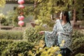 Asian Chinese woman in traditional Blue and white Hanfu dress, play in a famous garden ,sit on an ancient stone chair