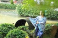 Asian Chinese woman in traditional Blue and white Hanfu dress, play in a famous garden ,sit on an ancient stone chair Royalty Free Stock Photo