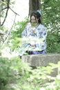 Asian Chinese woman in traditional Blue and white Hanfu dress, play in a famous garden ,sit on an ancient stone chair Royalty Free Stock Photo