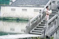 Asian Chinese woman in traditional cheongsam stand on a ancient bridge