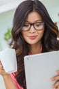 Asian Chinese Woman Using Tablet Computer Drinking Coffee or Tea