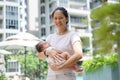 Asian chinese young mother carrying newborn child at her home swimming pool Royalty Free Stock Photo