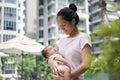 Asian chinese young mother carrying newborn child at her home swimming pool Royalty Free Stock Photo