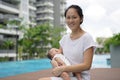 Asian chinese young mother carrying newborn child at her home swimming pool Royalty Free Stock Photo