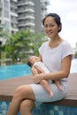 Asian chinese young mother carrying newborn child at her home swimming pool Royalty Free Stock Photo