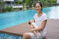 Asian chinese young mother carrying newborn child at her home swimming pool Royalty Free Stock Photo