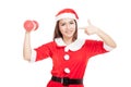 Asian Christmas girl with Santa Claus clothes point to red dumbbell Royalty Free Stock Photo