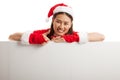 Asian Christmas Santa Claus girl thumbs up with blank sign. Royalty Free Stock Photo