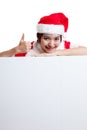 Asian Christmas Santa Claus girl thumbs up with blank sign. Royalty Free Stock Photo