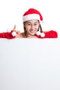 Asian Christmas Santa Claus girl thumbs up with blank sign. Royalty Free Stock Photo