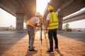 Asian civil engineer and surveyor engineers making measuring and pointing finger under the expressway with theodolite on road Royalty Free Stock Photo