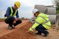 Asian civil engineers touching and inspecting laterite soil for construction improvement base road work. Inspection of each layer Royalty Free Stock Photo