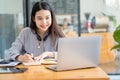 Asian students hang wireless headphones around their necks and write laptops to learn languages online. Watch and listen to laptop