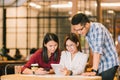 Asian college students or coworkers using digital tablet and smartphone together at coffee shop Royalty Free Stock Photo