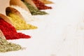 Asian colorful powder spices close up on white wooden board with copy space.