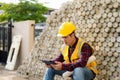 Asian construction site manager wearing safety vest and helmet thinking at architect construction Royalty Free Stock Photo