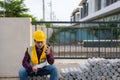 Asian construction site manager wearing safety vest and helmet thinking at architect construction Royalty Free Stock Photo