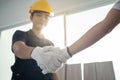 Asian Construction worker greeting by handshake with builder at home. Craftsman people wear yellow helmet, talk with Carpenter in Royalty Free Stock Photo