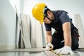 Asian Construction worker installs laminate board on floor in house. Craftsman builder or Carpenter male wear work safety helmet, Royalty Free Stock Photo