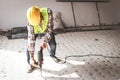 Asian construction worker using mortar extraction machine to drill concrete floor. Royalty Free Stock Photo