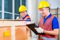 Asian construction workers on site open wood box