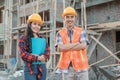 Asian construction workers smiling men and women at the camera wearing vests and safety helmets Royalty Free Stock Photo