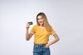 Asian content woman holding fan of money dollar banknotes and credit card and looking on copyspace isolated over gray