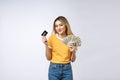Asian content woman holding fan of money dollar banknotes and credit card and looking on copyspace isolated over gray