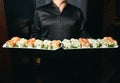 Asian cook hold a sushi roll dish Royalty Free Stock Photo