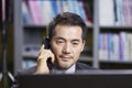 Asian corporate executive working in office talking on phone Royalty Free Stock Photo