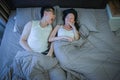 Asian couple with bad breath issues on bed at night Royalty Free Stock Photo