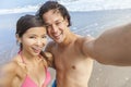 Asian Couple at Beach Taking Selfie Photograph Royalty Free Stock Photo