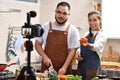 Asian couple blogger vlogger and online influencer recording video content on healthy food in the kitchen