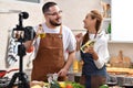 Asian couple blogger vlogger and online influencer recording video content on healthy food in the kitchen Royalty Free Stock Photo